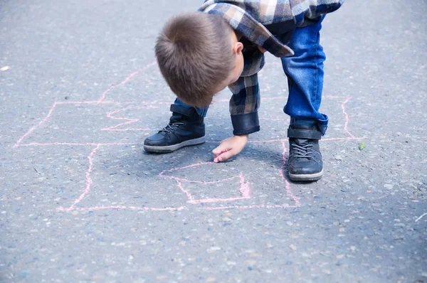Junge malen auf Asphaltkreide im Frühlingspark. — Stockfoto