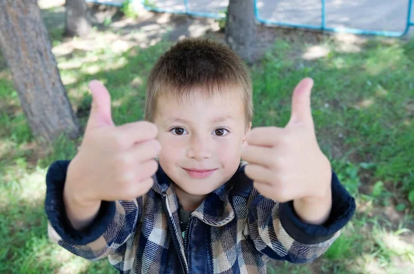 Kid mostrar polegar para cima sinal no verão no parque — Fotografia de Stock