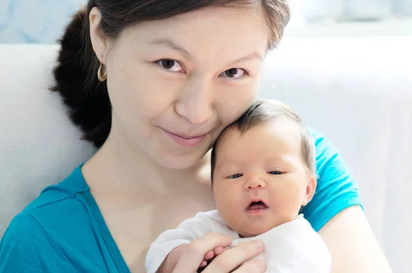 Asiática sonriente mujer sosteniendo bebé en sus brazos, feliz maternidad concepto —  Fotos de Stock