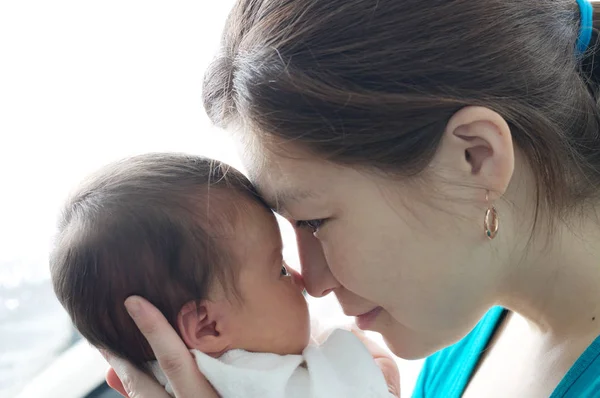 Asiática sonriente mujer sosteniendo bebé en sus brazos, feliz maternidad concepto —  Fotos de Stock