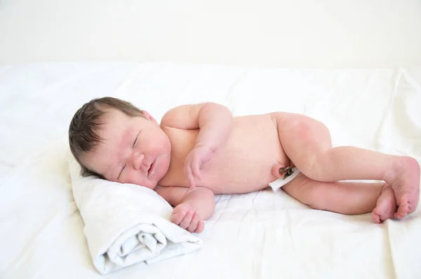 Baby baby met navelstreng vuist dag van leven liggend op draperie bladen — Stockfoto