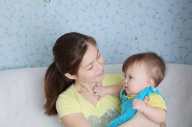 Anne ve çocuk, kadın ile küçük bebek, çok uluslu aile Asya anne ve beyaz kızı ile gülümseyen mutlu