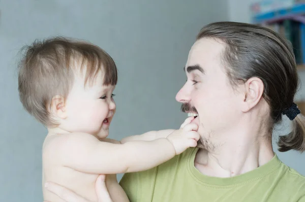 幼児の小さな女の子を保持しているハンサムなひげを生やした若い男 幸せな笑顔の父と赤ちゃんの娘肖像シンプルなライフ スタイルの幸福 — ストック写真