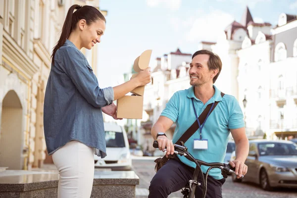 Cheerful courier delivering the parcel to smiling client — Stock Photo, Image