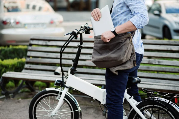 Hombre deportivo bien parecido poniendo portátil en la bolsa . — Foto de Stock