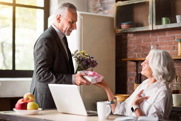 Anciano dando regalo y flores a su feliz esposa —  Fotos de Stock