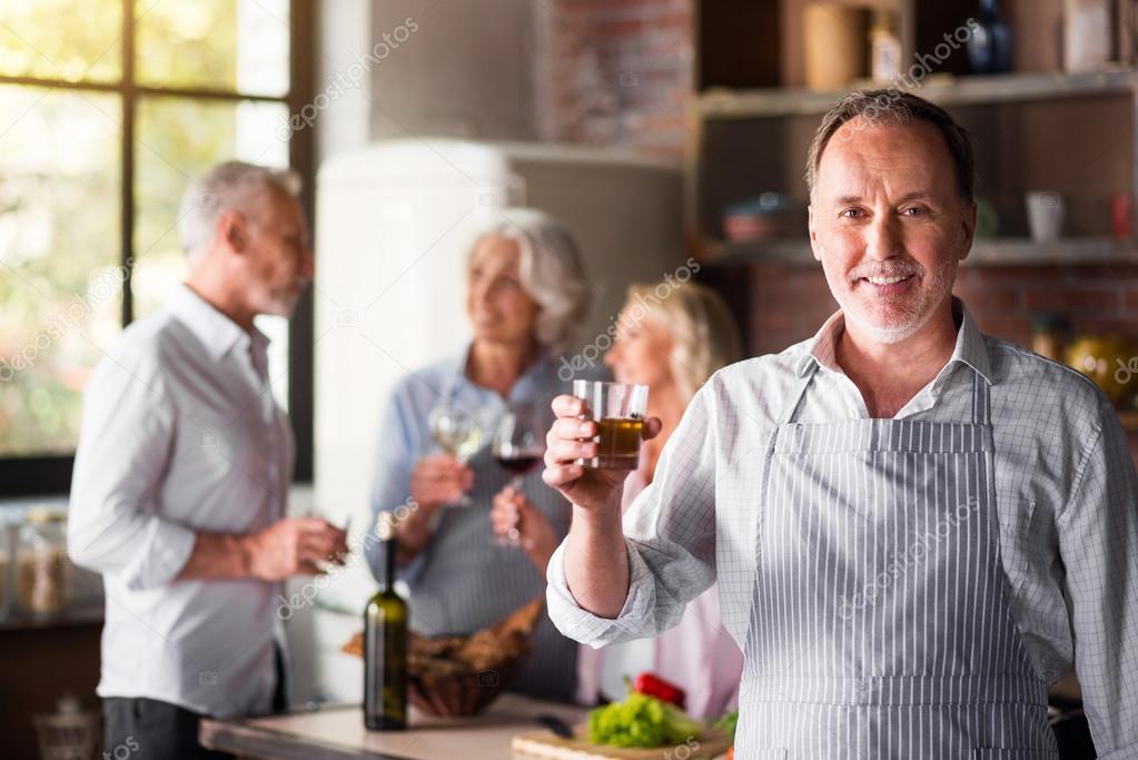 White middle-aged cook saying a toast looking at camera