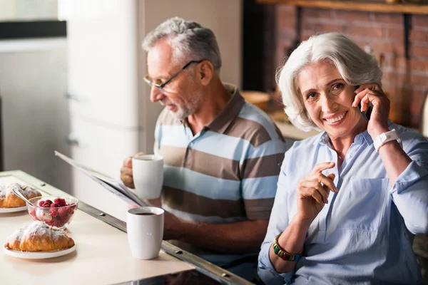 Sorridente coppia in pensione che prende il caffè del mattino in cucina — Foto Stock
