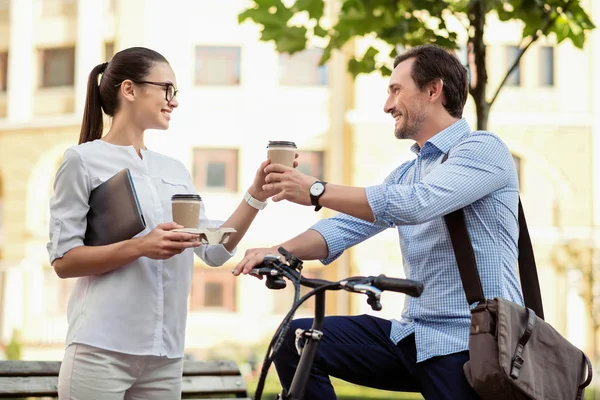 Усміхнена жінка ділиться кавою зі своїм колегою — стокове фото