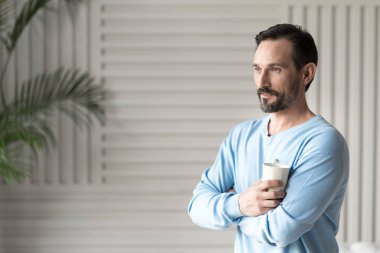 bir çay bardağı tutan olumlu adam 