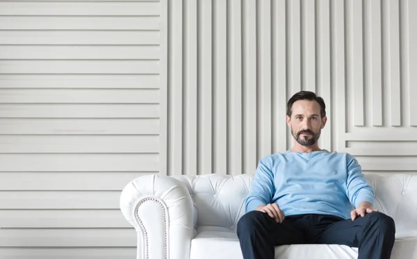 Hombre sentado en el medio del sofá — Foto de Stock