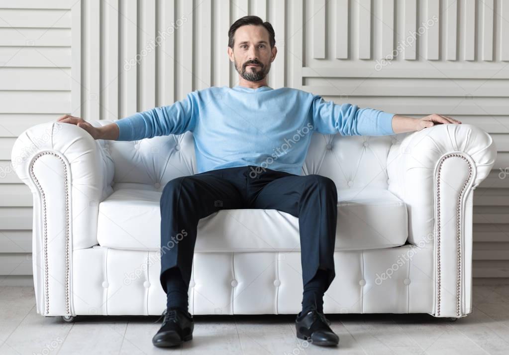 Confident handsome man sitting on a sofa