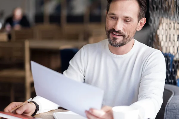 Lachende bebaarde man houden van papier — Stockfoto