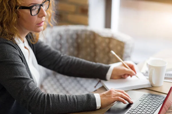 Tampilan samping dari wanita yang bekerja pada laptop — Stok Foto