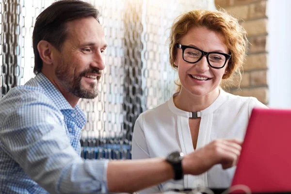 Middle-aged man and woman discussing information from laptop — Stock Photo, Image