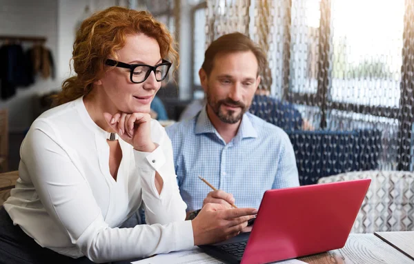 Middle-aged couple working on laptop and taking notes — Stock Photo, Image