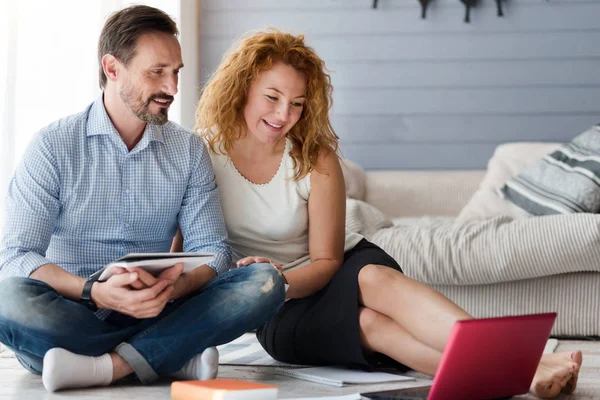 Mooi paar in de vloer zitten en kijken naar laptop — Stockfoto