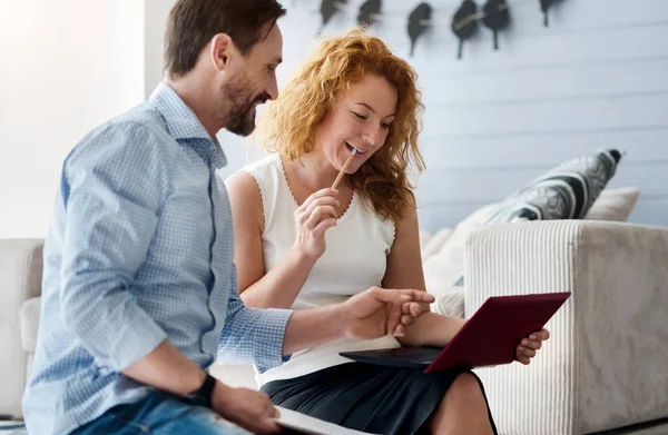 Sorrindo casal trabalhando com laptop em casa — Fotografia de Stock