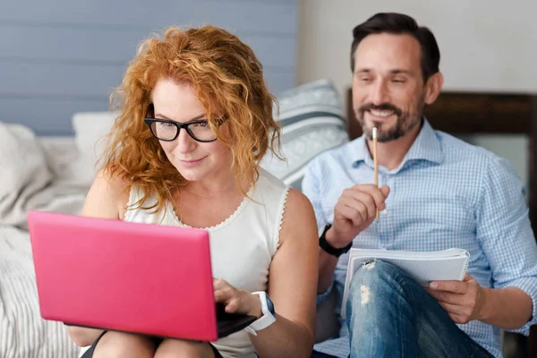 Donna che lavora con il computer portatile mentre l'uomo prende appunti — Foto Stock