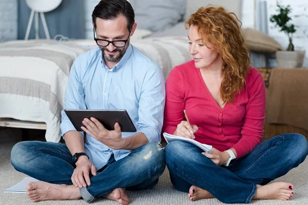 Couple d'âge moyen utilisant une tablette à la maison — Photo