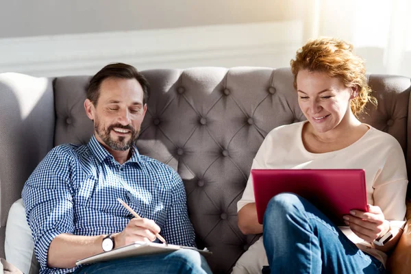 Paar sitzt mit Laptop und Notizen auf Couch — Stockfoto