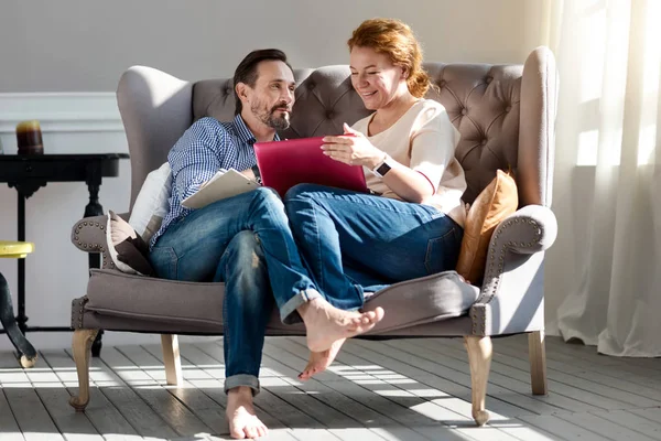 Paret sitter på soffan med laptop och anteckningar — Stockfoto