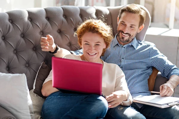Paret sitter på soffan med laptop och anteckningar — Stockfoto