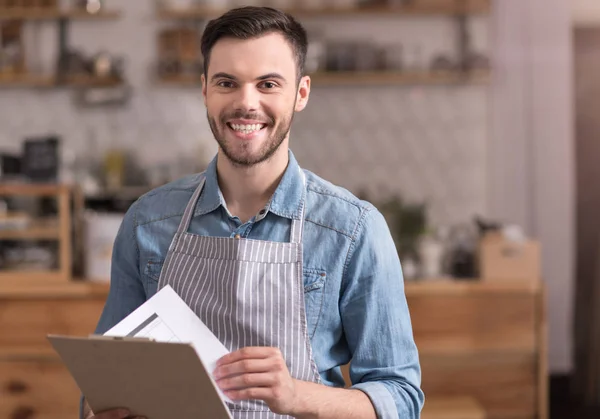 Deliziato giovane uomo sorridente in possesso di una cartella . — Foto Stock