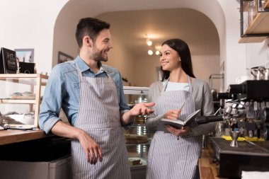 Duygusal çift kahve makinesinde işaret ve gülümseyen.