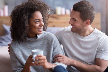 Gülümseyen adam sevgilisini kucaklayan