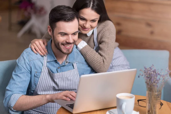 Happy couple smiling and using laptop. — Stock Photo, Image