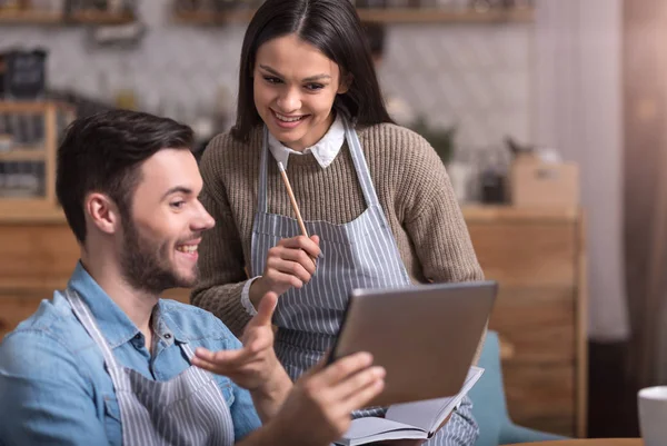 Encantado jovem casal fazendo anotações e usando tablet . — Fotografia de Stock