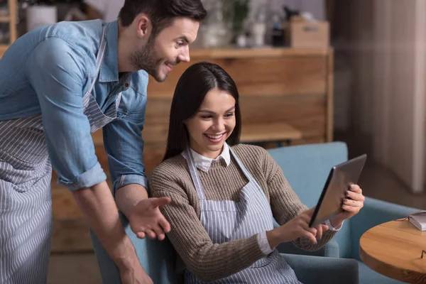 Satisfied overjoyed couple laughing and using tablet — Stock Photo, Image