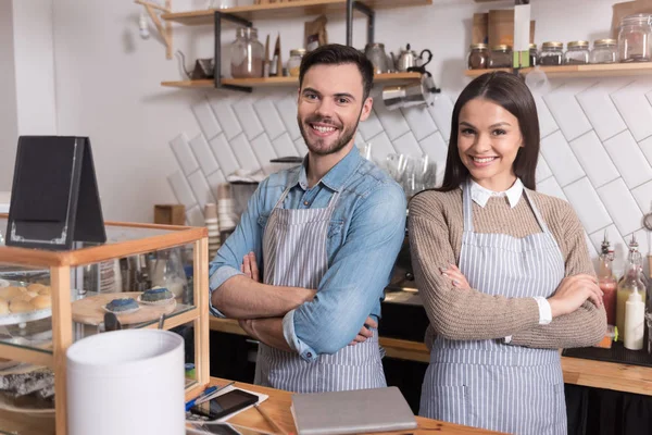 Cute couple crossing hands and standing behind bar. — Stock Photo, Image