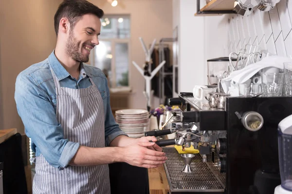 Garçom bonito encantado usando máquina de café . — Fotografia de Stock