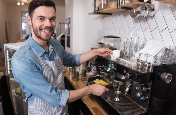 Pelayan tampan yang gembira menggunakan mesin kopi. . — Stok Foto
