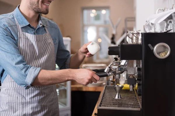 Agréable homme souriant utilisant une machine à café . — Photo