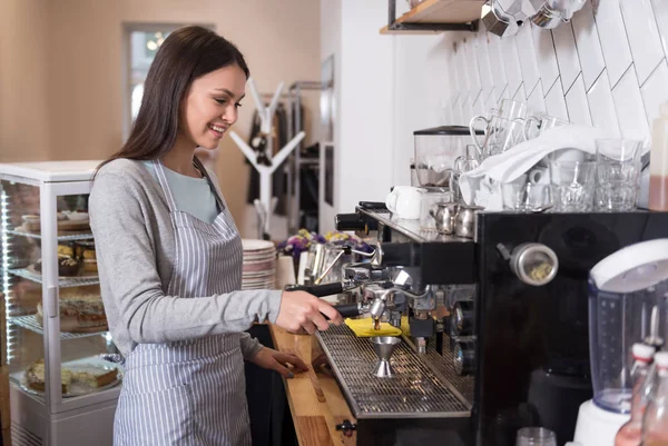 Souriant belle femme en utilisant une machine à café — Photo