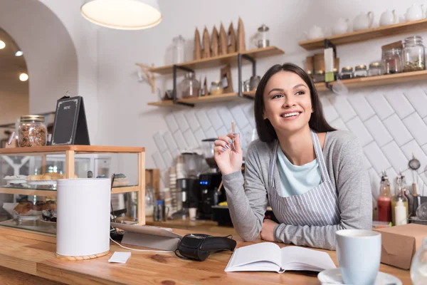 Hermosa mujer inspirada tomando notas durante el trabajo . — Foto de Stock