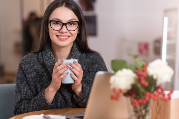 : Delighted beautiful woman relaxing in a cafe