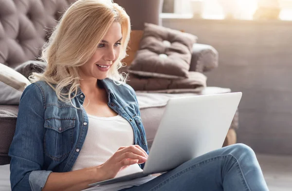 Blondine arbeitet zu Hause mit Laptop — Stockfoto