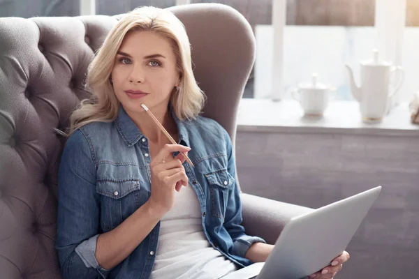 Mulher atenciosa com laptop em casa — Fotografia de Stock