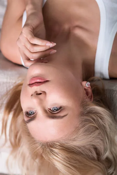 Närbild på blond kvinna liggande på sängen — Stockfoto