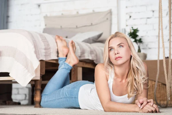 Vrouw liggend op de vloer in de slaapkamer — Stockfoto