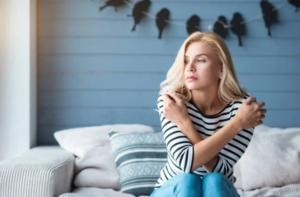 Woman with crossed arms on couch — Stock Photo, Image