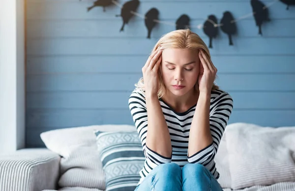 Lady liggande röra tempel på soffa — Stockfoto