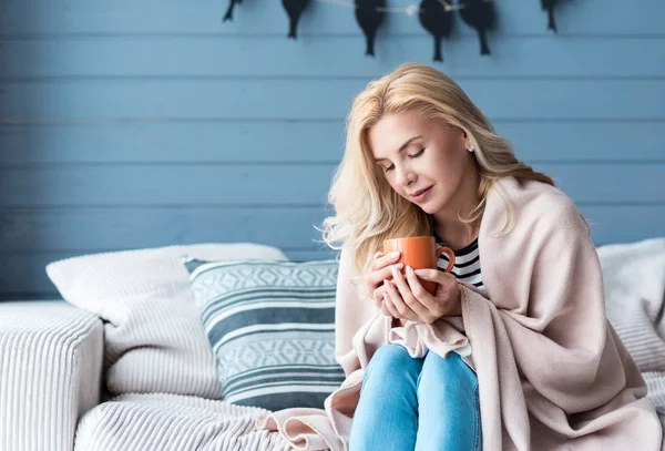 Frau sitzt auf Sofa mit Tasse — Stockfoto