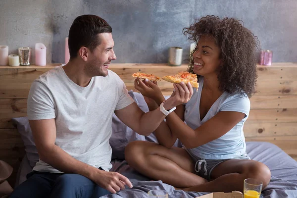 Pareja alimentándose mutuamente con pizza . — Foto de Stock