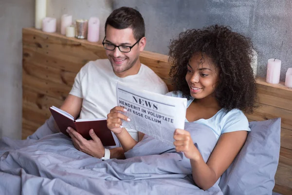 Coppia lettura mentre sdraiato a letto — Foto Stock