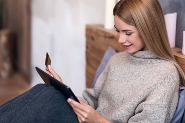 Gülümseyen kadın yatakta online alışveriş sahip